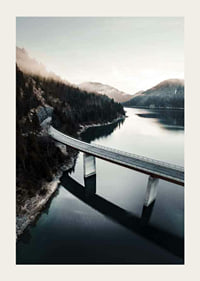 Photographic bridge over calm lake with forested mountains-3