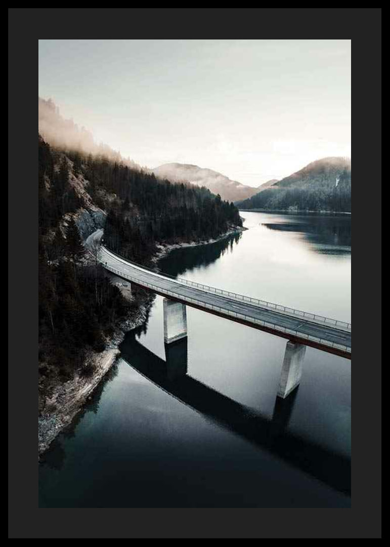 Photographic bridge over calm lake with forested mountains-12