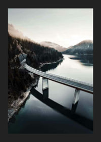 Photographic bridge over calm lake with forested mountains-5
