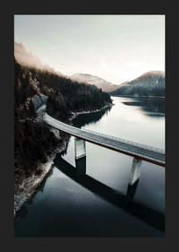 Fotografisk bro över lugn sjö med skogsklädda berg-5