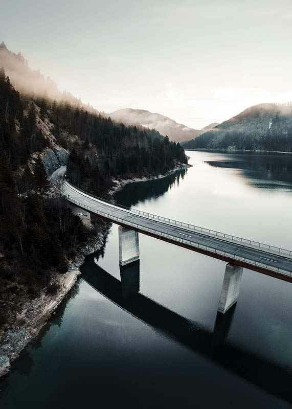 Photographic bridge over calm lake with forested mountains-12
