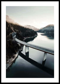 Photographic bridge over calm lake with forested mountains-0