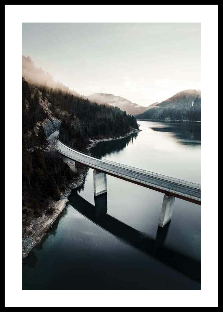 Photographic bridge over calm lake with forested mountains-12