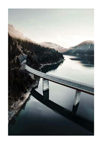 Photographic bridge over calm lake with forested mountains-1