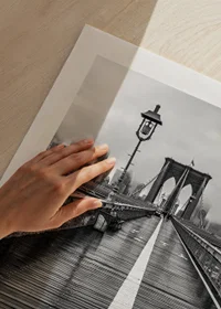 Black and white photograph of Brooklyn Bridge with wet wooden surface-9