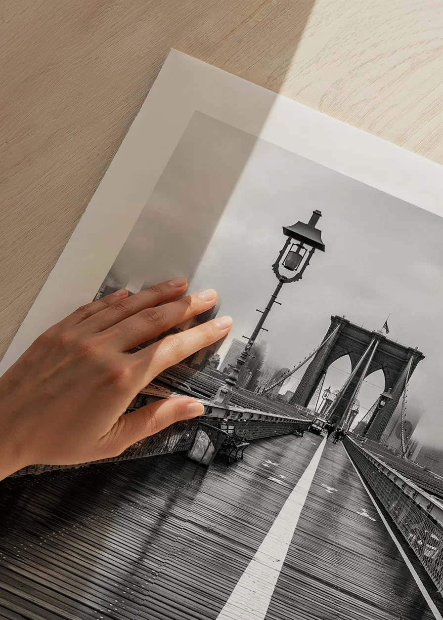 Black and white photograph of Brooklyn Bridge with wet wooden surface-12