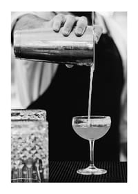 Bartender häller drink i cocktailglas-1