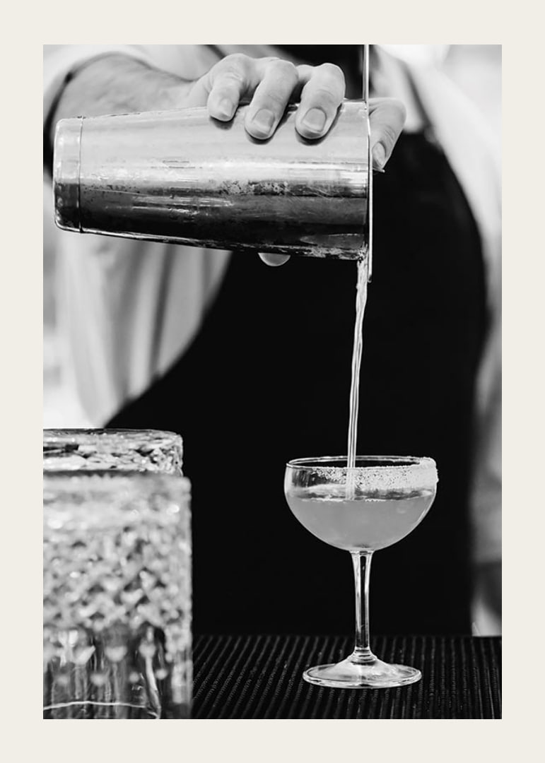 Bartender häller drink i cocktailglas-12