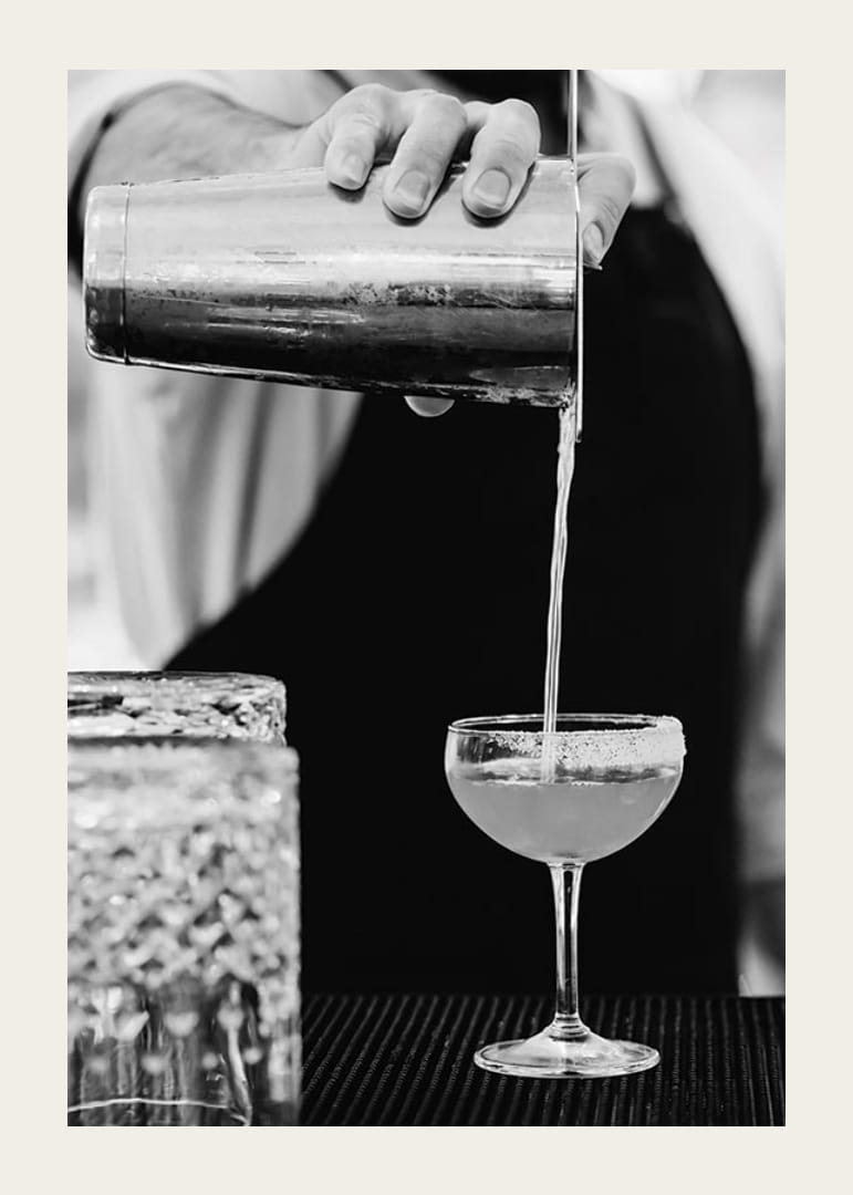 Bartender häller drink i cocktailglas-12