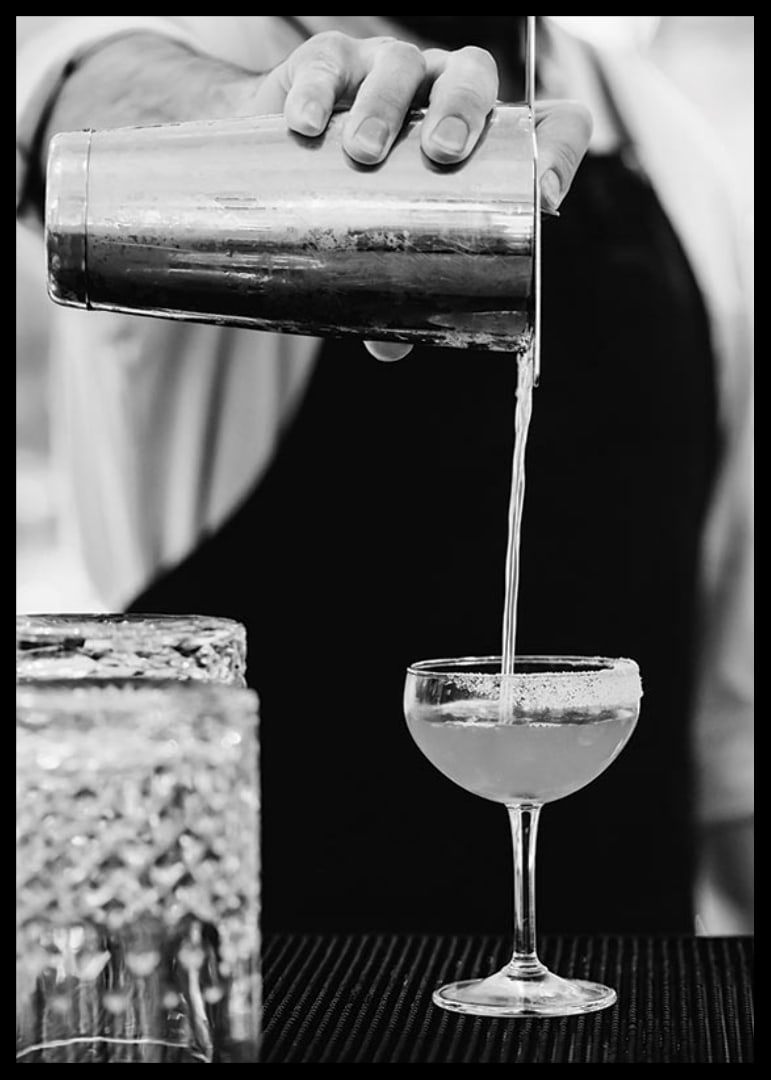 Bartender häller drink i cocktailglas-12