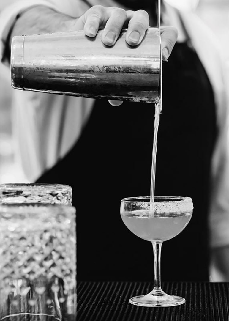 Bartender häller drink i cocktailglas-12