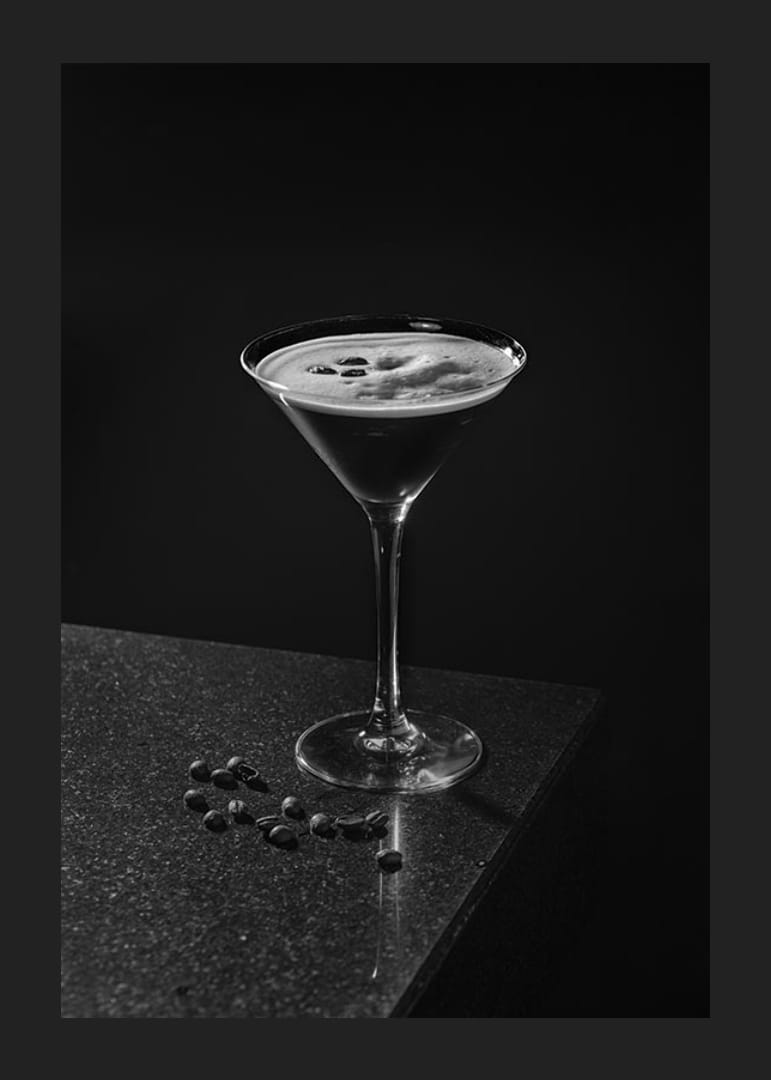 Foto in bianco e nero di un Espresso Martini in un bicchiere da cocktail con chicchi di caffè-12