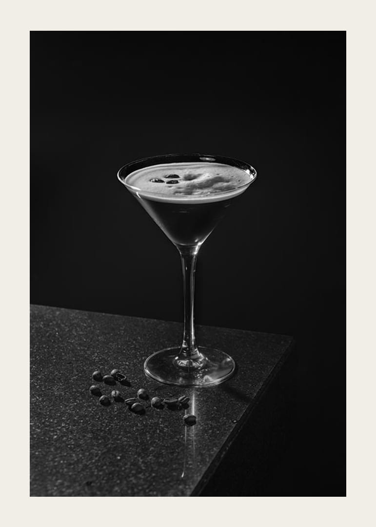 Foto in bianco e nero di un Espresso Martini in un bicchiere da cocktail con chicchi di caffè-12