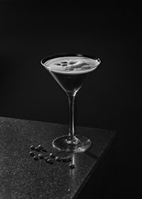 Foto in bianco e nero di un Espresso Martini in un bicchiere da cocktail con chicchi di caffè-7