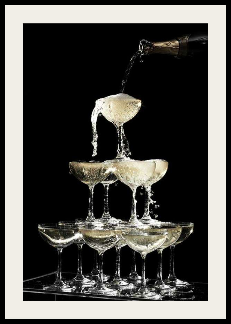 Photograph of champagne tower with flowing bubbles against black background-12