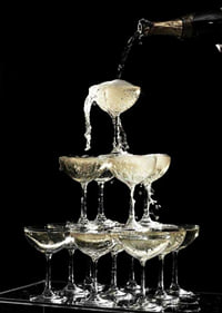 Photograph of champagne tower with flowing bubbles against black background-7