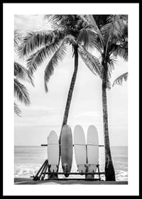 Black and white photo of surfboards against palm trees and ocean-0