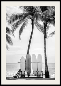 Black and white photo of surfboards against palm trees and ocean-2
