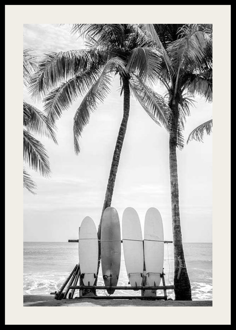 Black and white photo of surfboards against palm trees and ocean-12