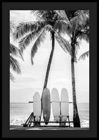 Black and white photo of surfboards against palm trees and ocean-4