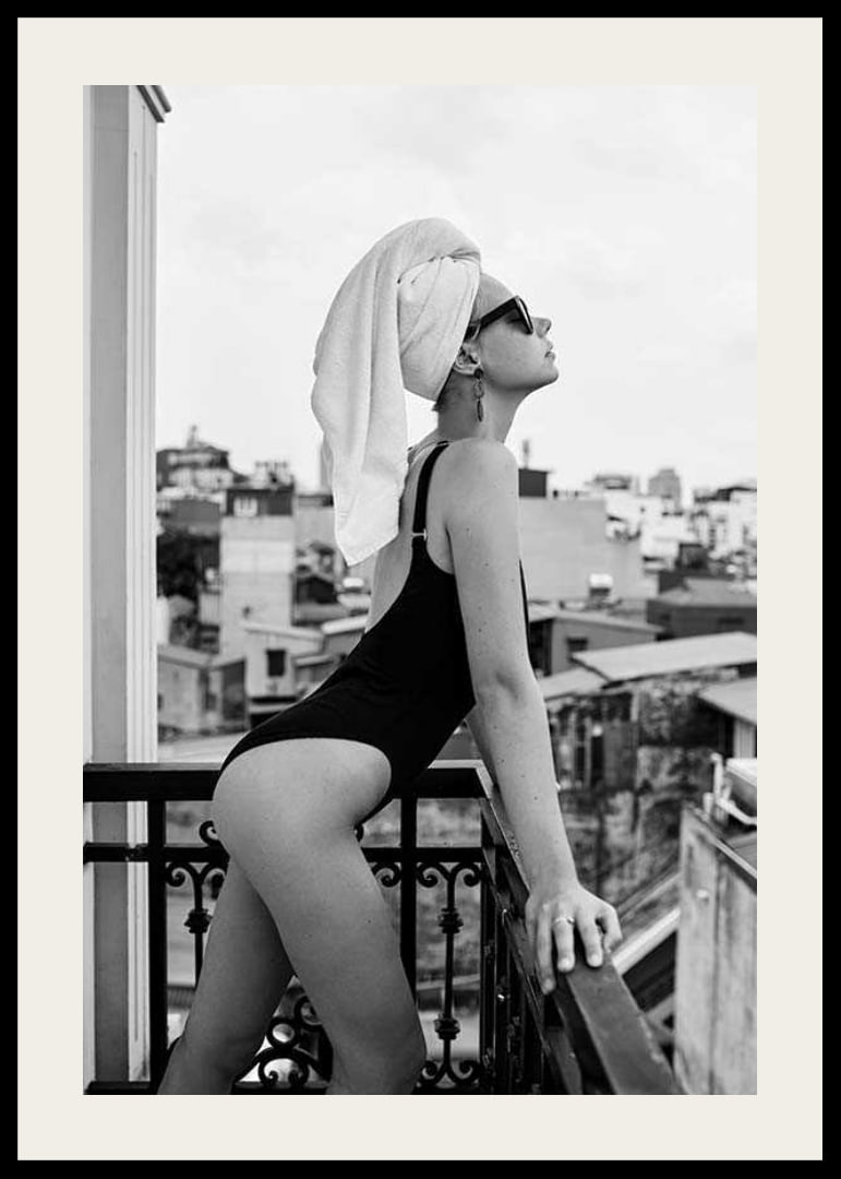 Black and white photograph of woman in swimsuit on balcony-12