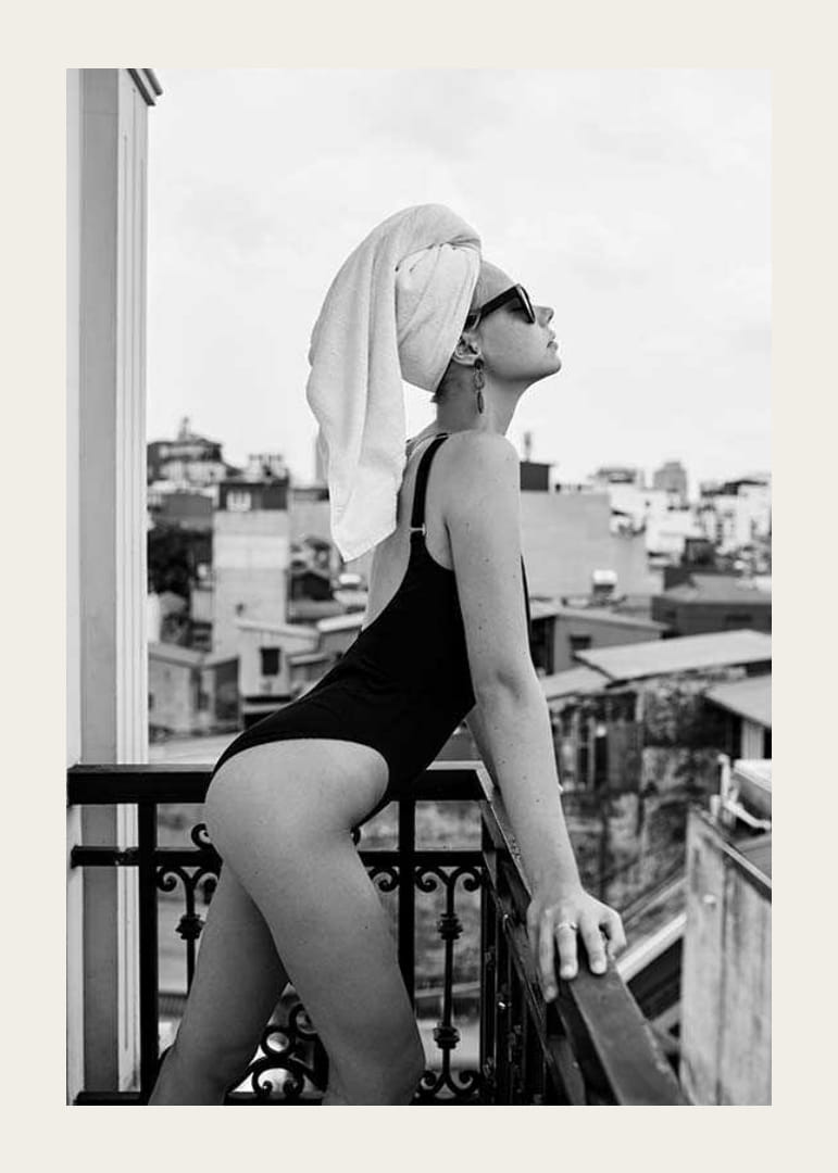 Svartvitt fotografi av kvinna i baddräkt på balkong-12