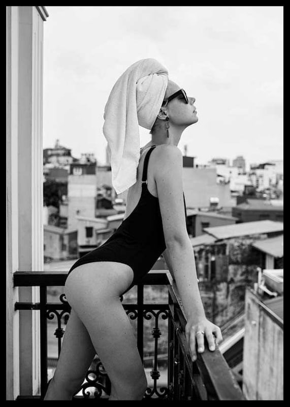 Black and white photograph of woman in swimsuit on balcony-12