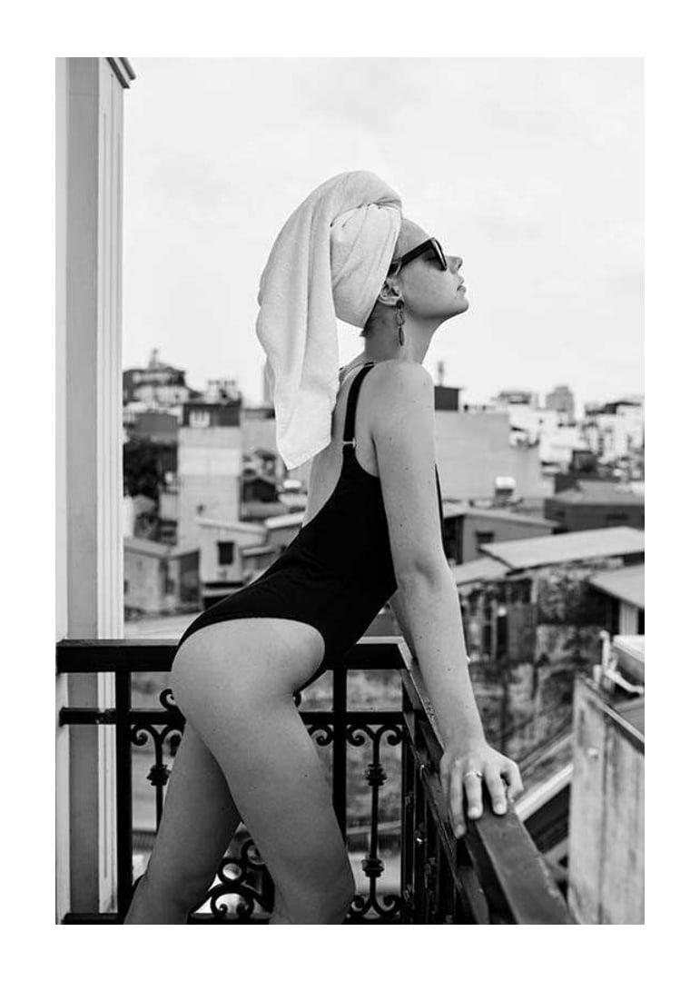 Black and white photograph of woman in swimsuit on balcony-12