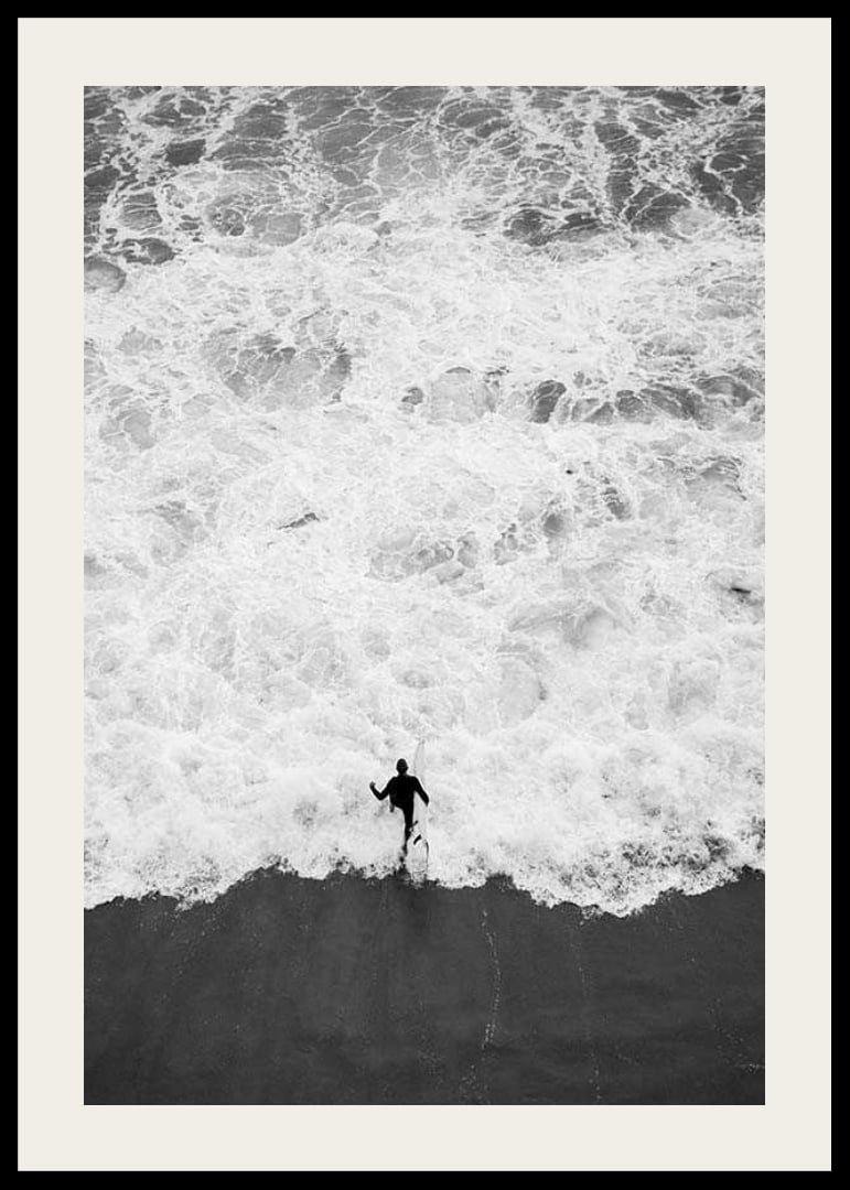 Black and white photo of person running towards wavy sea-12