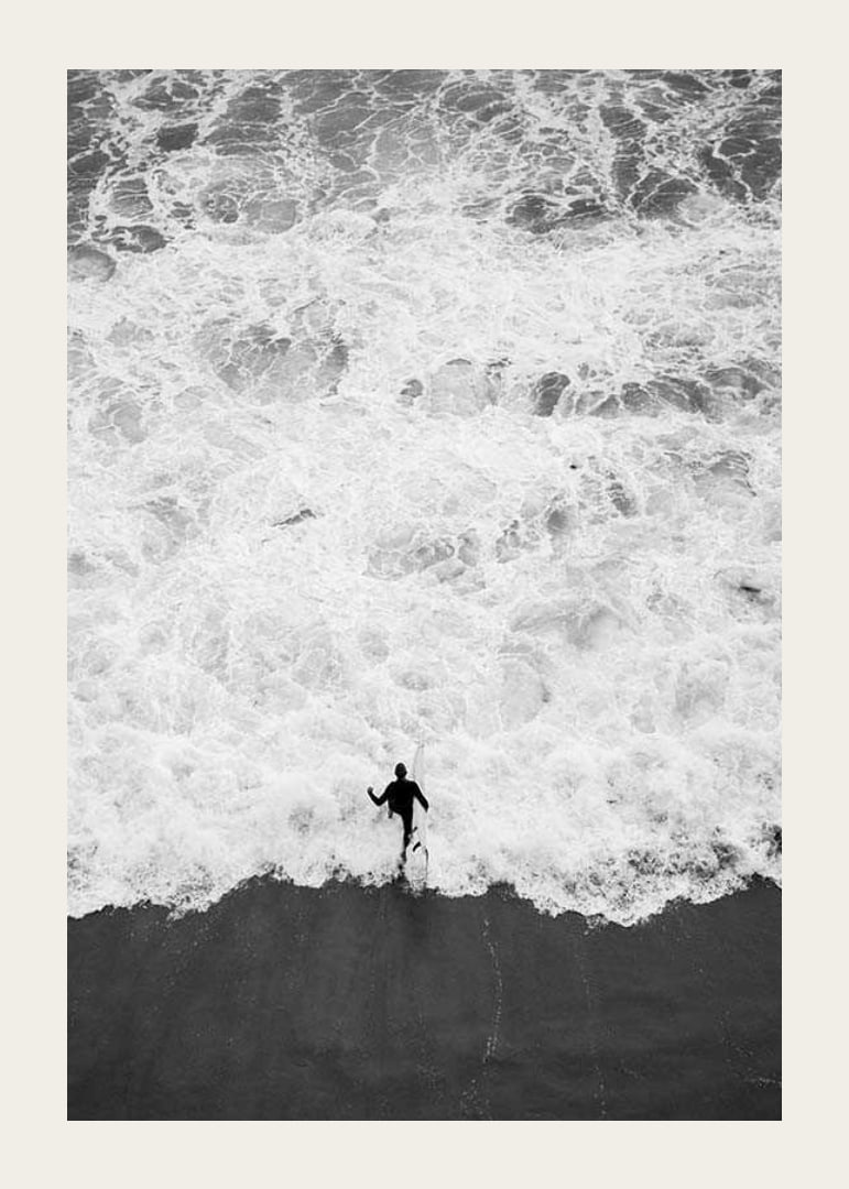 Black and white photo of person running towards wavy sea-12