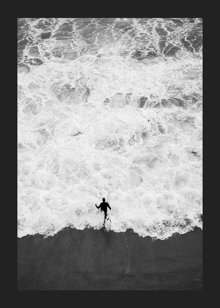 Black and white photo of person running towards wavy sea-12