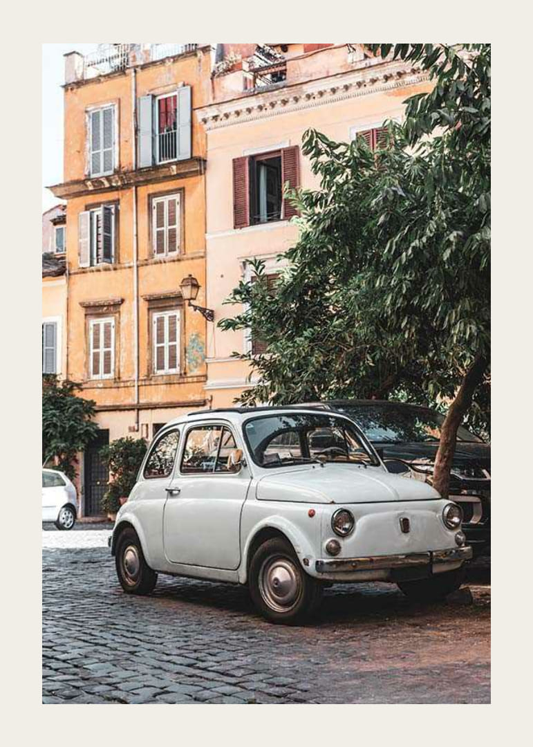 Foto eines weißen italienischen Oldtimers auf einer Kopfsteinpflasterstraße-12