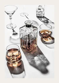 Photograph of whiskey decanter and glass with ice on light surface-3