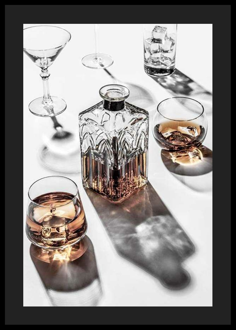 Fotografia di una caraffa di whisky e di un bicchiere con ghiaccio su una superficie chiara-12