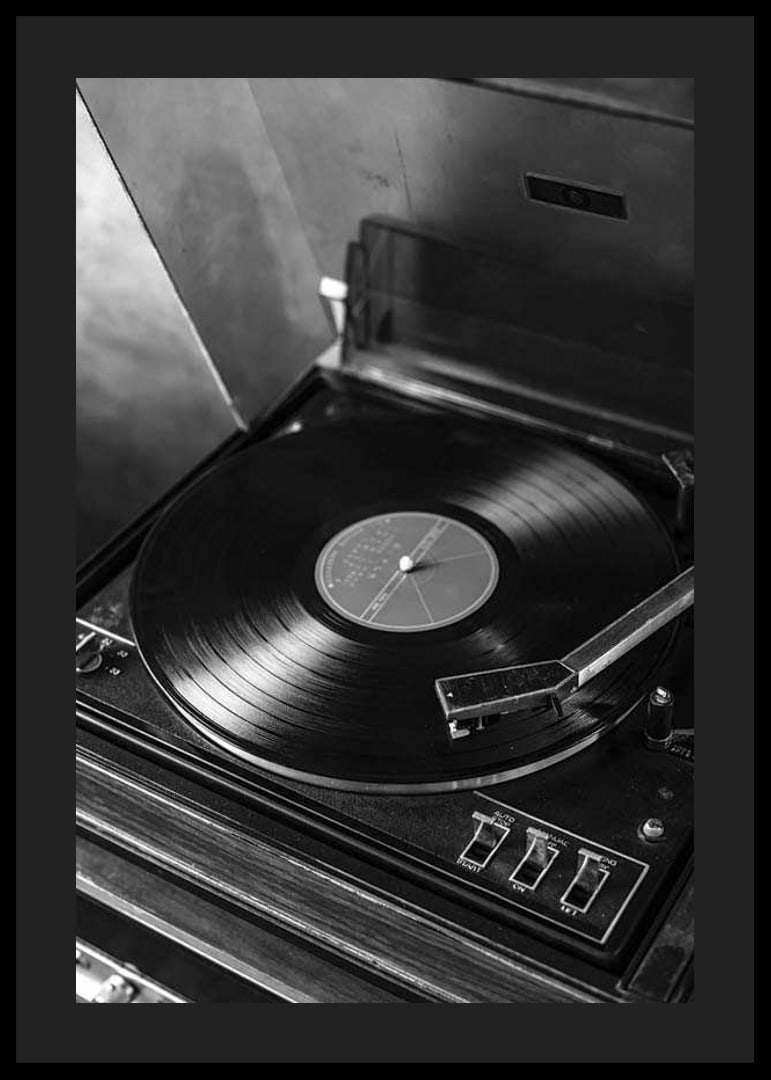 Black and white close-up of classic vinyl player with record-12