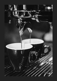 Svartvitt foto av espressomaskin med två kaffekoppar-1