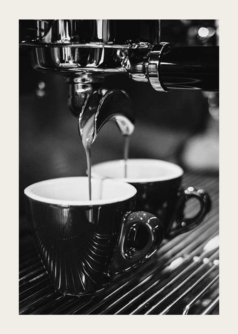 Schwarz-Weiß-Foto einer Espressomaschine mit zwei Kaffeetassen-12