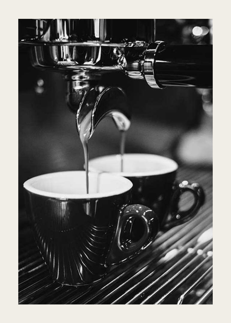 Svartvitt foto av espressomaskin med två kaffekoppar-12