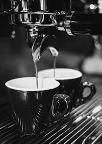 Schwarz-Weiß-Foto einer Espressomaschine mit zwei Kaffeetassen-7