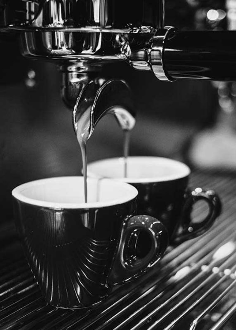Schwarz-Weiß-Foto einer Espressomaschine mit zwei Kaffeetassen-12
