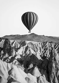 Black and white photograph of hot air balloon over dramatic landscape-7