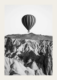 Black and white photograph of hot air balloon over dramatic landscape-3