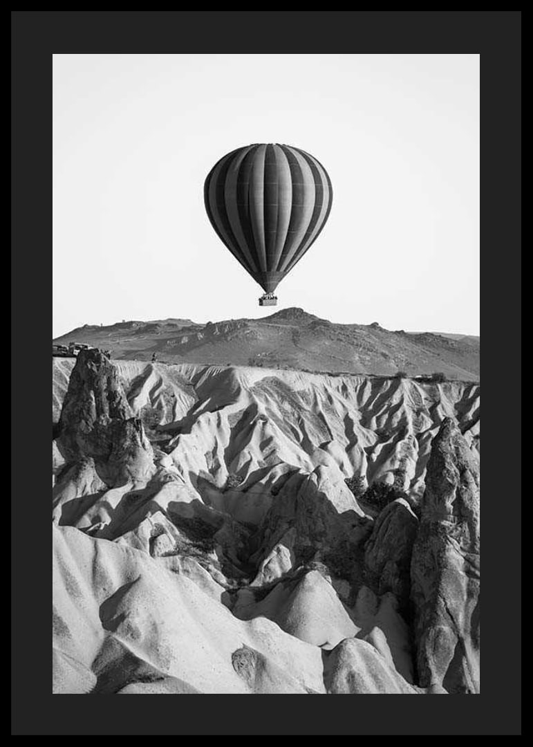 Black and white photograph of hot air balloon over dramatic landscape-12