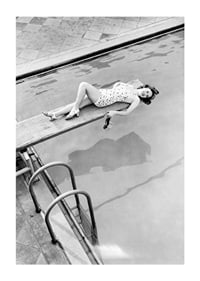 Black and white photograph of woman on trampoline above pool-1