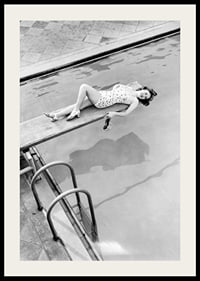 Black and white photograph of woman on trampoline above pool-2