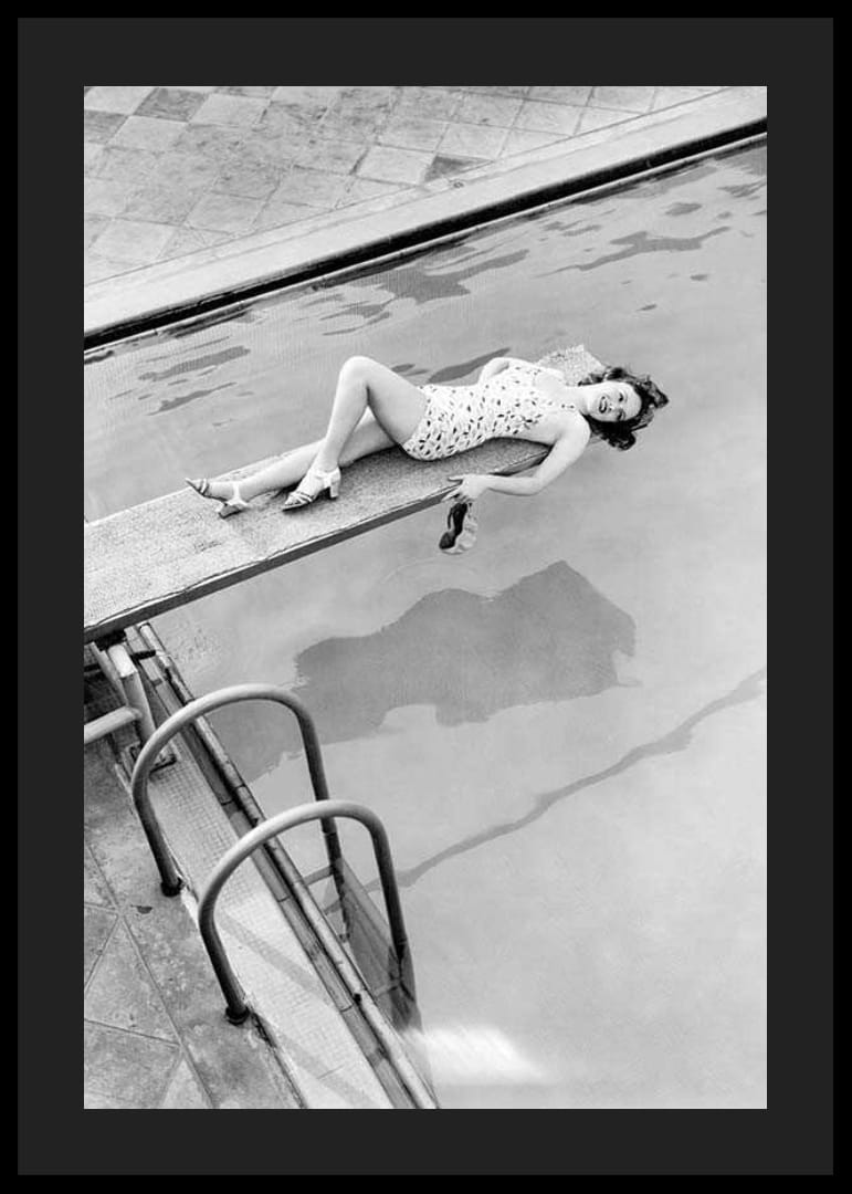 Fotografía en blanco y negro de una mujer en un trampolín sobre una piscina.-12