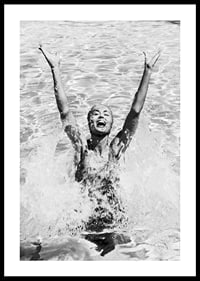 Black and white photo of smiling woman splashing water in pool-0