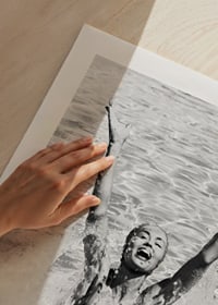 Black and white photo of smiling woman splashing water in pool-9
