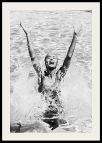 Schwarz-Weiß-Foto einer lächelnden Frau, die im Pool Wasser planscht-2