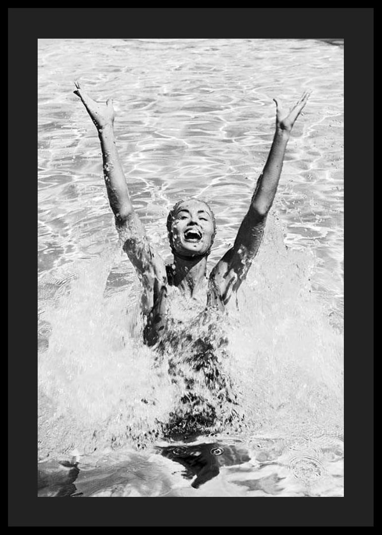 Black and white photo of smiling woman splashing water in pool-12